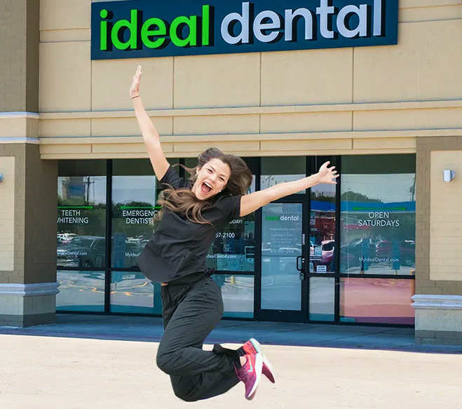 Girl jumping in front of Ideal Dental Office